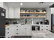 Well-lit kitchen with white cabinetry, floating shelves, and a striking backsplash, perfect for modern living at 13419 N 35Th St, Phoenix, AZ 85032