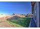 Wide backyard with green grass and a tall block wall for privacy; a covered patio is in the background at 1357 S Loma Vis, Mesa, AZ 85204