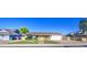 Single-story home featuring a well-manicured lawn, brick pathway, and a bright yellow front door at 1357 S Loma Vis, Mesa, AZ 85204