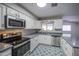 Bright kitchen featuring white cabinets, stainless steel appliances, stylish flooring, and modern countertops at 1357 S Loma Vis, Mesa, AZ 85204