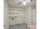 Bright laundry area with open shelving, patterned floor, washer hookups, and a ceiling fan at 1357 S Loma Vis, Mesa, AZ 85204