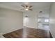 Open-concept living room featuring hardwood floors, neutral walls, ceiling fan, and an open view into the kitchen at 1357 S Loma Vis, Mesa, AZ 85204