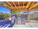 Well-equipped outdoor kitchen under a covered patio, with a built-in grill and counter space at 1357 S Loma Vis, Mesa, AZ 85204