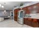Kitchen with dark cabinets and stainless steel fridge, leading into a spacious living area at 1414 W Grovers Ave, Phoenix, AZ 85023