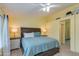 A bedroom with yellow walls, a ceiling fan, and a bed with blue and white bedding at 1414 W Grovers Ave, Phoenix, AZ 85023