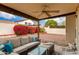 Covered patio with comfortable outdoor furniture, fan, and lush garden views at 1414 W Grovers Ave, Phoenix, AZ 85023