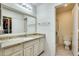 Bathroom featuring granite countertops, a large mirror, and a separate toilet and shower area at 14300 W Bell Rd # 245, Surprise, AZ 85374