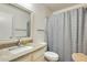 Bright bathroom featuring a granite-topped vanity, sink, and patterned shower curtain at 14300 W Bell Rd # 245, Surprise, AZ 85374