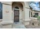 Charming front entrance with a decorative security door and well-maintained stucco exterior with the house number above the door frame at 14300 W Bell Rd # 245, Surprise, AZ 85374