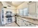 Functional kitchen with white cabinets, granite countertops, and stainless steel appliances at 14300 W Bell Rd # 245, Surprise, AZ 85374