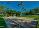 Outdoor shuffleboard court with groomed lanes, surrounded by lush greenery and palm trees at 14300 W Bell Rd # 245, Surprise, AZ 85374