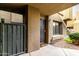 Building entrance featuring a private gate and a secure door, complemented by rock landscaping and greenery at 1432 W Emerald Ave # 648, Mesa, AZ 85202