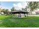 Community gazebo with picnic table and trash receptacle, perfect for outdoor gatherings on lush green grass at 1432 W Emerald Ave # 648, Mesa, AZ 85202