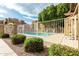 Community pool area featuring a clean pool, well-maintained decking, and lush landscaping in a fenced in area at 1432 W Emerald Ave # 648, Mesa, AZ 85202