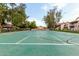 Community tennis court with surrounding greenery, picnic tables, and ample space for tennis enthusiasts at 1432 W Emerald Ave # 648, Mesa, AZ 85202