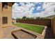 Spacious backyard with artificial turf, a wooden planter box, and a secure privacy wall at 14733 N 159Th Dr, Surprise, AZ 85379