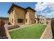 Large backyard boasting a well-maintained artificial lawn, covered patio, and exterior of the home at 14733 N 159Th Dr, Surprise, AZ 85379