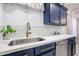 Bright kitchen features navy cabinets, stainless appliances, updated sink, and white countertops at 14733 N 159Th Dr, Surprise, AZ 85379