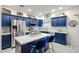 Well-lit kitchen with blue cabinets, stainless steel appliances, and a white countertop island at 14733 N 159Th Dr, Surprise, AZ 85379