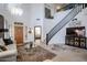Open-concept living area with staircase, wood door and plenty of natural light at 14733 N 159Th Dr, Surprise, AZ 85379