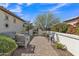 Relaxing backyard patio with brick pavers, seating area, and well-maintained landscaping at 1556 E Vesper Trl, Queen Creek, AZ 85140