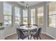 Cozy breakfast nook with a round table, four chairs, and natural light from the surrounding windows at 1556 E Vesper Trl, Queen Creek, AZ 85140