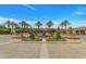 Beautiful community entrance featuring palm trees, lush landscaping, and a tranquil fountain at 1556 E Vesper Trl, Queen Creek, AZ 85140