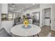 Open dining area featuring a round table, modern chairs, and a view into the kitchen and living area at 1556 E Vesper Trl, Queen Creek, AZ 85140