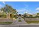 Elegant community entrance with brick signage, verdant landscaping, and palm trees at 1556 E Vesper Trl, Queen Creek, AZ 85140
