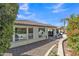 The exterior features a backyard with an outdoor seating area and luscious green trees at 1556 E Vesper Trl, Queen Creek, AZ 85140