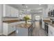 Bright kitchen with white cabinetry, granite countertops, stainless steel appliances, and a view to the living room at 1556 E Vesper Trl, Queen Creek, AZ 85140