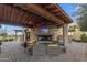 Cozy outdoor living space with fireplace, plush seating, and covered patio at 1556 E Vesper Trl, Queen Creek, AZ 85140