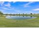 Tranquil pond reflecting the clear blue sky in the middle of the beautiful golf course at 1556 E Vesper Trl, Queen Creek, AZ 85140