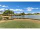 Scenic view of a serene pond with a waterfall on the golf course at 1556 E Vesper Trl, Queen Creek, AZ 85140