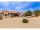 Spacious backyard featuring a covered patio, desert landscaping, and privacy, ideal for relaxation and outdoor activities at 16331 W Tierra Way, Surprise, AZ 85374