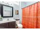 Cozy bathroom with a vanity and a shower featuring an orange shower curtain at 16331 W Tierra Way, Surprise, AZ 85374