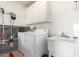Functional laundry room with washer, dryer, utility sink, and ample cabinet space for storage and organization at 16331 W Tierra Way, Surprise, AZ 85374