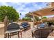 Outdoor patio featuring comfortable seating, a built-in grill, and lush landscaping for relaxing and entertaining at 16331 W Tierra Way, Surprise, AZ 85374