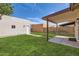 Cozy backyard featuring a covered patio, green grass, and block fence for privacy at 16513 N 68Th Dr, Peoria, AZ 85382