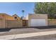 Attached two-car garage with white door, accessed from the paved driveway, with a decorative privacy wall surrounding the property at 16513 N 68Th Dr, Peoria, AZ 85382