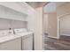 Practical laundry room with shelving and machines, offering convenient storage and functionality at 16513 N 68Th Dr, Peoria, AZ 85382