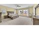 Bright main bedroom with a large window, neutral carpet, and a wooden bed frame at 1694 E Mia Ln, Gilbert, AZ 85298