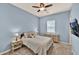 Inviting bedroom with blue walls, a ceiling fan and a plush queen-sized bed at 1694 E Mia Ln, Gilbert, AZ 85298