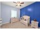 Bedroom boasts a board and batten wall, neutral carpet, and a ceiling fan at 1694 E Mia Ln, Gilbert, AZ 85298
