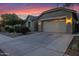 Charming single-Gathering home featuring a two-car garage, well-manicured landscaping, and a cozy facade at sunset at 1694 E Mia Ln, Gilbert, AZ 85298