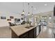Open-concept kitchen island with seating, seamlessly flowing into the living and dining areas at 1694 E Mia Ln, Gilbert, AZ 85298