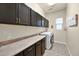 Functional laundry room with ample cabinetry, countertop space, and modern washer and dryer at 1694 E Mia Ln, Gilbert, AZ 85298