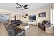 Inviting living room features a plush leather sectional, neutral paint, and a ceiling fan at 1694 E Mia Ln, Gilbert, AZ 85298