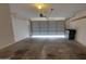 The garage features a concrete floor, mounted shelves, and an automatic door opener at 17151 W Mohave St, Goodyear, AZ 85338