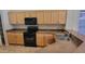 Efficient kitchen with sleek black appliances, wood cabinets, and plenty of countertop space at 17151 W Mohave St, Goodyear, AZ 85338